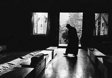 An exiled Tibetan nun walks across the room after a meditation session in a convent.