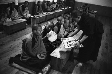 Exiled Tibetan nuns are offered bread in the dining room of the convent.