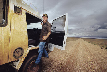 Postman Derik Rowi climbs into the cab of his truck in which he makes 12 hour trips across the Australian desert delivering post to remote farmers in the outback.