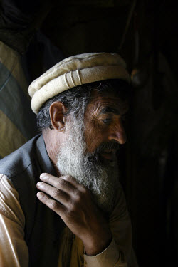 Muhannad Ifaq (55) sits with his son inside their shelter in Pokal. Muhannad's wife died when their home collapsed as an earthquake struck the region. One year later, thousands of people are still wai...