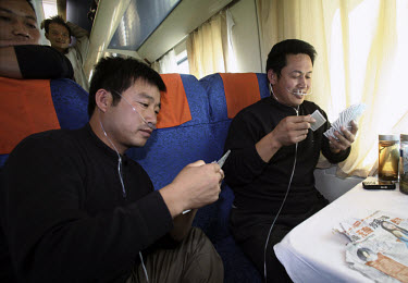 Chinese tourists relax and play cards during a train journey along the Qingzang (Qinghai-Tibet) railway. Oxygen is provided at high altitudes for the safety and comfort of the passengers. Travelling a...