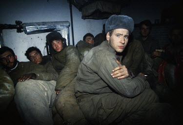 Fifteen Russian solders huddle together in darkness in a room in the Presidential Palace in Grozny after they were captured during the disastrous invasion of New Year's Eve 1995.