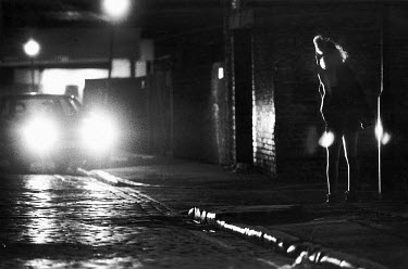 A young sex worker solicits clients on a street corner in the King's Cross area.
