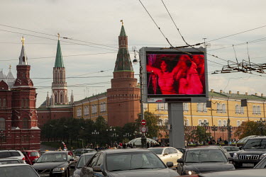 An erotic nightclub is advertised on an electronic billboard in front of the Kremlin.