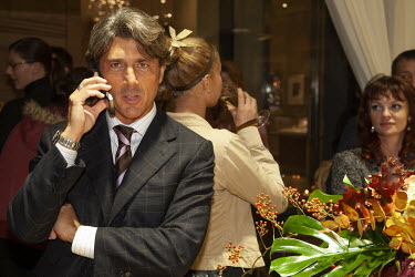 A wealthy businessman talks on his mobile phone during the opening of a new de Grisogono designer jewellery store in an affluent Moscow suburb.