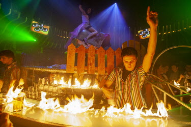 A barman dances behind a bar that has been set on fire at the fashionable Opera Nightclub. The Russian nouveau-riche (nicknamed the ^New Russians^) have become renowned for flaunting their wealth.