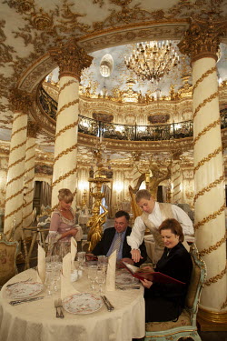 A waiter and waitress assist diners at the extravagant Turandot Restaurant.
