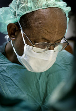 Dr. Asrat Mengiste, an Ethiopian doctor working for the African Medical and Research Foundation (AMREF), wears a surgical facemask while he performs an operation at KCMC hospital. AMREF, an internatio...