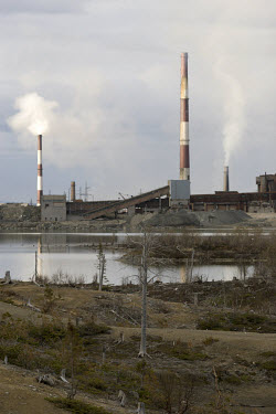 The smokestacks of a nickel-copper smelting refinery, owned by Norilsk Nickel Corporation, tower over the dead trees and polluted man-made ponds on the Kola Peninsula in Monchegorsk. Climate change co...