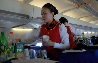 Air hostesses serving drinks to passengers. Chinese aviation has taken off with numerous regional carriers flying Boeing and Airbus planes on new and expanded routes.