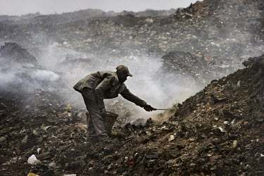 A scavenger searches through rubbish at the Olusosun landfill site. The Olusosun dump is Nigeria's largest trash heap comprising over 100 acres of garbage and is believed to be the largest in Africa....
