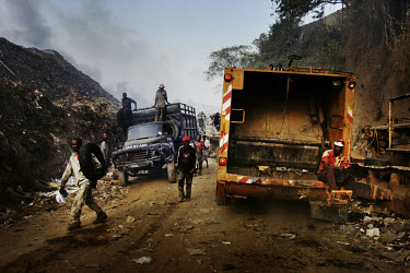 Scavengers and trucks enter and leave the Olusosun landfill site. The Olusosun dump is Nigeria's largest trash heap comprising over 100 acres of garbage and is believed to be the largest in Africa. Th...