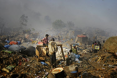 Scavengers at the Olusosun landfill site. The Olusosun dump is Nigeria's largest trash heap comprising over 100 acres of garbage and is believed to be the largest in Africa. There are around a thousan...