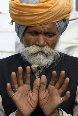 A bearded Sikh man with an orange turban.