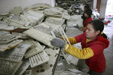 Migrant workers sort plastic computer keyboard components in an e-waste recycling workshop. Every year Guiyu receives more than a million tons of computer waste from countries all over the world. Abou...