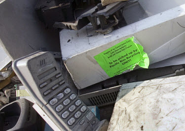 A recycling sticker on an old scanner in a pile of American electronic trash at an e-waste recycling workshop. Every year Guangdong receives more than a million tons of computer waste from countries a...