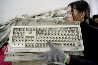 A worker at an e-waste recycling workshop carries the plastic casings of old computer keyboards to a grinder where they will be chopped up into plastic flakes. Every year Guiyu receives more than a mi...