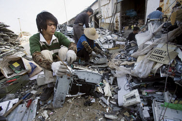 A migrant worker dismantles an old printer at an e-waste recycling workshop. Every year Guangdong receives more than a million tons of computer waste from countries all over the world. About 100,000 e...