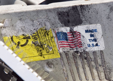 A sticker depicting an American flag on an old computer in an e-waste junkyard. Every year Guangdong receives more than a million tons of computer waste from countries all over the world. About 100,00...