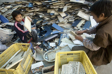 Migrant workers sort plastic computer keyboard components at an e-waste recycling workshop. Every year Guiyu receives more than a million tons of computer waste from countries all over the world. Abou...