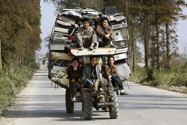 Workers transport a large stack of old computers on a small tractor. The electronic waste will be dismantled and disposed of at a nearby e-waste recycling workshop. Every year Guangdong receives more...