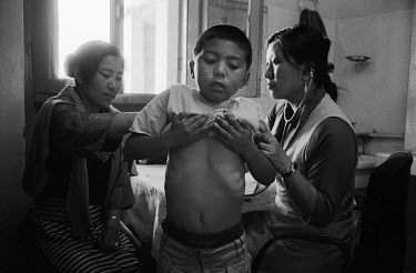 A doctor examines a young boy at a Tibetan clinic in Dharamsala, the largest Tibetan exile settlement in northern India.