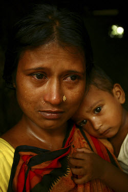 An anxious sex worker with her child during eviction day at the Tangail brothel. The existence of the brothel is under threat from both Islamists and land grabbers. Many of the region's brothels, whic...