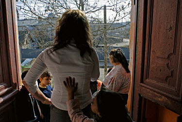 Beatrice, a 20 year old sex worker from Cernavoda, with her family in the doorway of their house.  She went back to her large (nine siblings), poor Roma family after working as a sex worker in Spain....