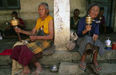 Elderly Tibetan women with prayer wheels at a refugee settlement in eastern India.