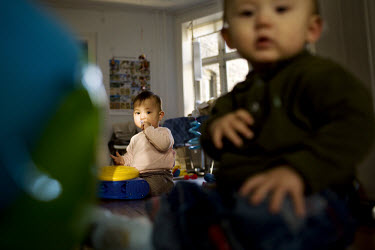 10-month-old twin babies, a brother and sister, playing at home.
