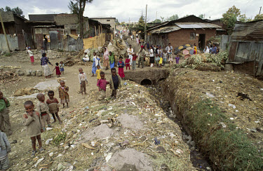 Open sewers and poor housing conditions in a city slum area.