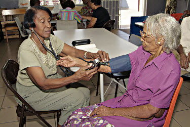 Dorrie Huie having her blood pressure checked by nurse Ivy Holder at the Providence Methodist Day Centre.