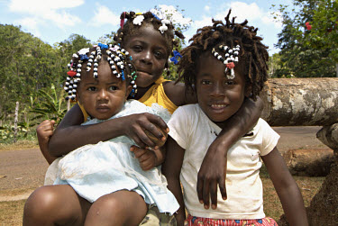 Three young sisters with beaded hair.