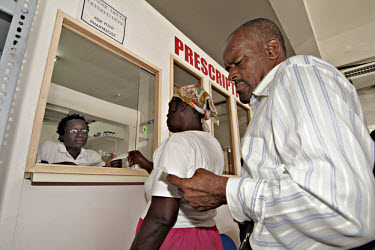 Mavis Vincent and Dennis Thompson getting their prescription drugs, which are subsidised by the government, at the local pharmacy.