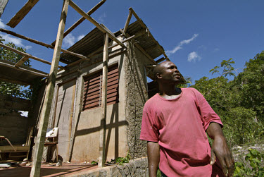 Allan Laing standing next to his house. The building had its front blown off during Hurricane Ivan.