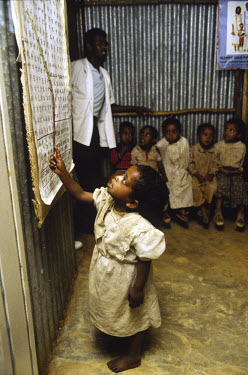 A young child points to the board at a school in one of the city's slums.