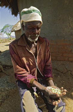 An old man holding his last handful of maize during a period of prolonged drought.