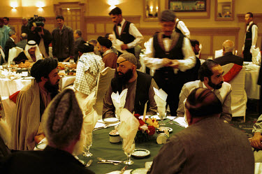 An Iftar dinner at the Marriott hotel organised by the Muslim World Congress. The iftar meal is held after sundown during Ramadan. In the centre is the distinctive figure of Ahmad Ratib, sporting an e...