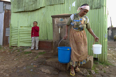 A woman collecting water from a community tap in the Lideta slum area.