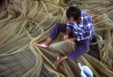 A fisherman mending his nets.
