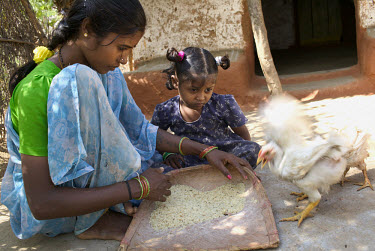 A mother and daughter work cleaning rice outside their home in Gopala Swamy Gutta.