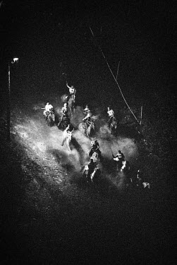 Riders plunge down the 210 feet drop of 'Suicide Hill' in the first of four races. The Omak Suicide Race is part of the Omak Stampede, a rodeo which is held on the Colville Native American / Indian Re...