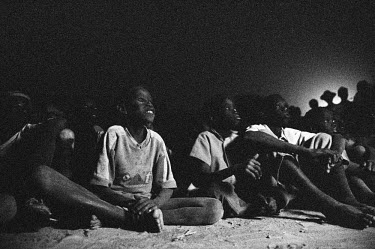 Children watching  health/HIV education videos in the evening during the Twic Olympics. 3,000 young competitors and spectators came together in Twic county, southern Sudan, to compete in the first Twi...