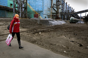 A female worker at the Norilsk Nickel factory walking home with an Estee Lauder bag. The Norilsk Nickel Corporation in Monchegorsk is known as one of the most polluting companies in Russia. There is a...