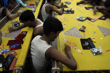 Migrant labourers working in an embroidery workshop at a factory in Dharavi, one of Asia's largest slums. They live as well as work at this factory.