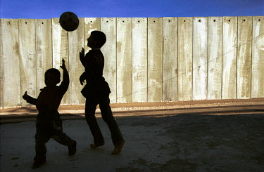 Palestinian kids from the Amer family play soccer near their house in the West Bank village of Mascha, where a new section of the separation wall / barrier is being constructed. The Amer family house...