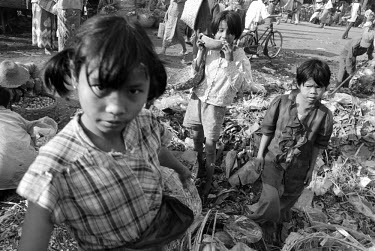 Children collecting discarded fruit and vegetables from a rotting spoil heap in the middle of Zegyo market. The children scavenge the food both to eat and to sell on.