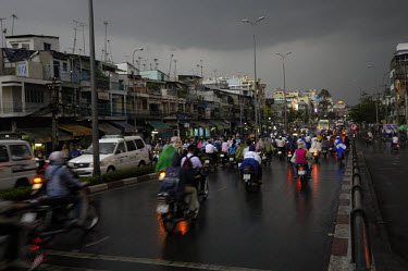 Two-wheeled rush hour traffic with rain capes in a heavy storm.
