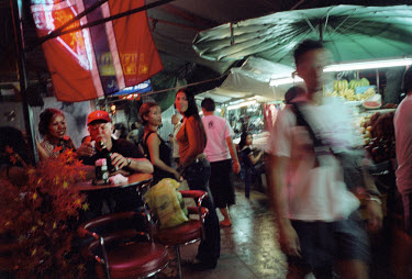 A tourist shares a drink with a sex worker at a bar in Bangkok.