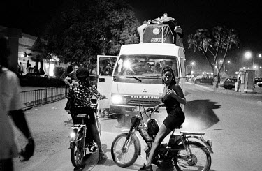 sex workers on small motorbikes arrive in Ouagadougou to greet cyclists taking part in the Tour du Faso. The Tour du Faso is Africa's greatest cycle race, attracting participants from across the world...